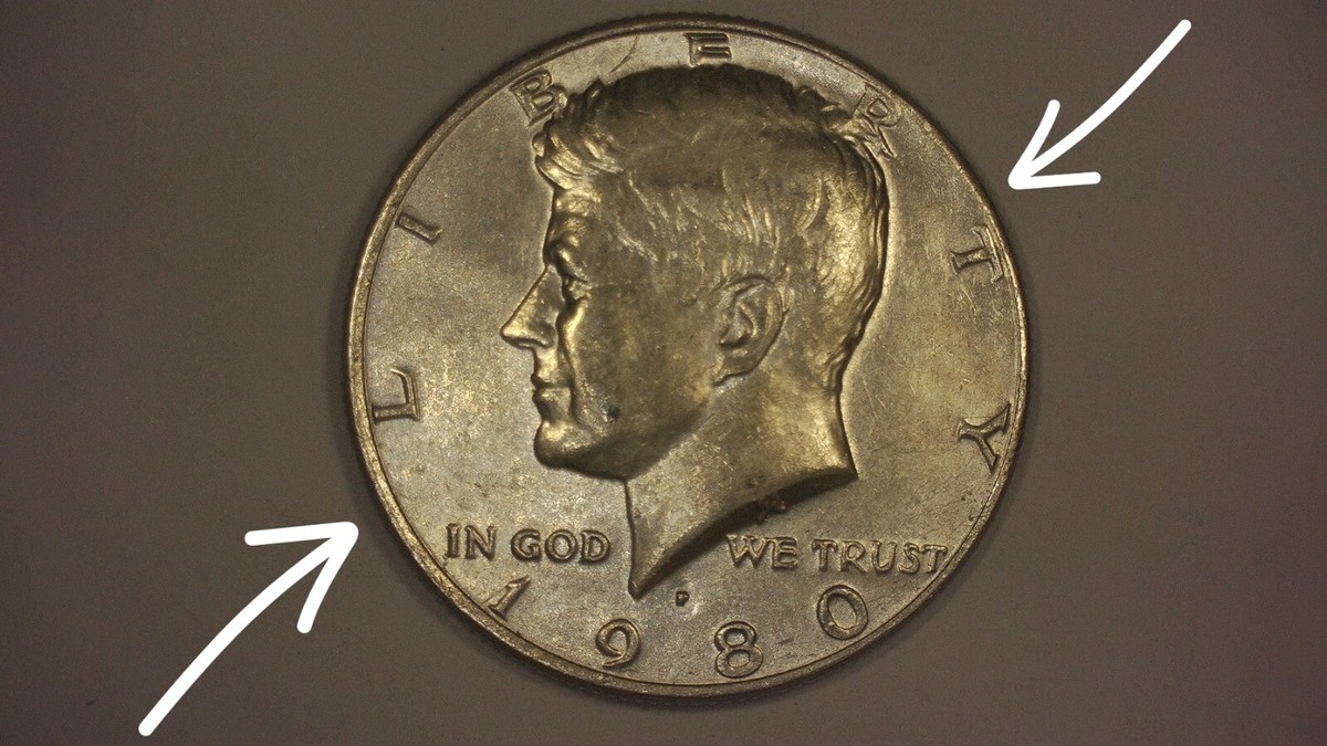 1980 Kennedy half dollar off-center strike showing partial design and blank planchet area